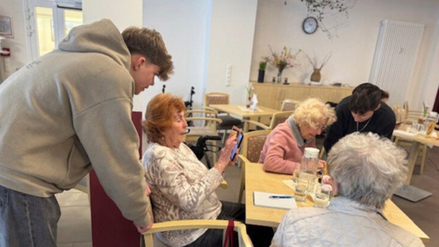 Geduldig erklärten die Schüler*innen der BundtStift Schule Strausberg den Mieter*innen von ProCurand Wriezener Straße die Grundlagen der Smartphone-Nutzung – ein erfolgreicher Auftakt für die digitale Zukunft!