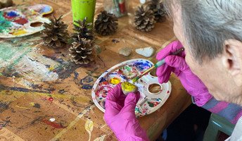In der ProCurand Seniorenresidenz Senftenberg bemalten Bewohner*innen gemeinsam mit Alltagsbegleiterin Corina Gill liebevoll bunte Steine.