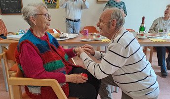 Detlef kniet vor Marianne im ProCurand Seniorenzentrum Am Herzogschloss – ein romantischer Heiratsantrag, der alle Bewohner*innen berührte.