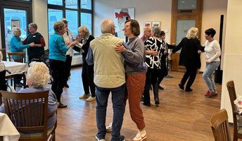 Bewohner*innen, Mieter*innen und Gäste genießen gemeinsam Musik, Tanz und Austausch im Restaurant Vier Jahreszeiten der ProCurand Seniorenresidenz Bölschestraße.