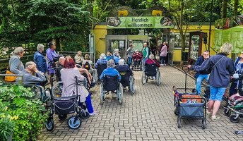 Vorfreude pur – die Senior*innen posieren gemeinsam am Zooeingang, bereit für einen erlebnisreichen Tag.