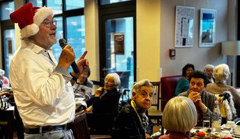 Musikalische Unterhaltung bei der Weihnachtsfeier in der ProCurand Seniorenresidenz Bölschestraße: Alf Weis singt, begleitet von Gitarrist Sebastian Grytzka, viele Bewohner*innen hören zu und singen mit.