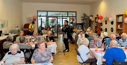 In der ProCurand Seniorenresidenz Park Sanssouci in Potsdam sorgt Sänger Dirk Jüttner für Stimmung: Die Senior*innen genießen an dekorierten Tischen die Hits der 50er und 60er Jahre.