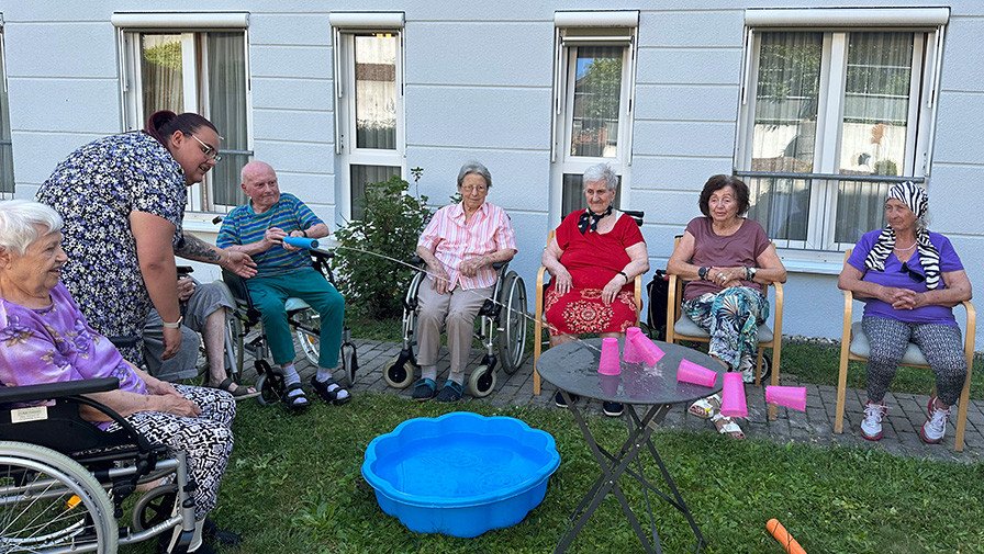 Bewohner*innen und Mitarbeiter*innen des ProCurand Pflegestifts Pfarrer Lukas liefern sich bei sommerlichen Temperaturen eine fröhliche Wasserschlacht – für Abkühlung und ganz viel Spaß!