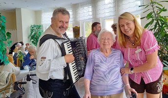 Musiker, Seniorin und Einrichtungsleitung beim  Oktoberfest in der ProCurand Seniorenresidenz Am Straussee 