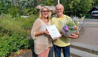 Die Einrichtungsleitung der ProCurand Seniorenresidenz am Straussee, Janin Tiedemann, gratuliert dem langjährigen Mitarbeiter Dietmar Heinitz mit einem Blumenkorb und einer Urkunde zum Jubiläum.