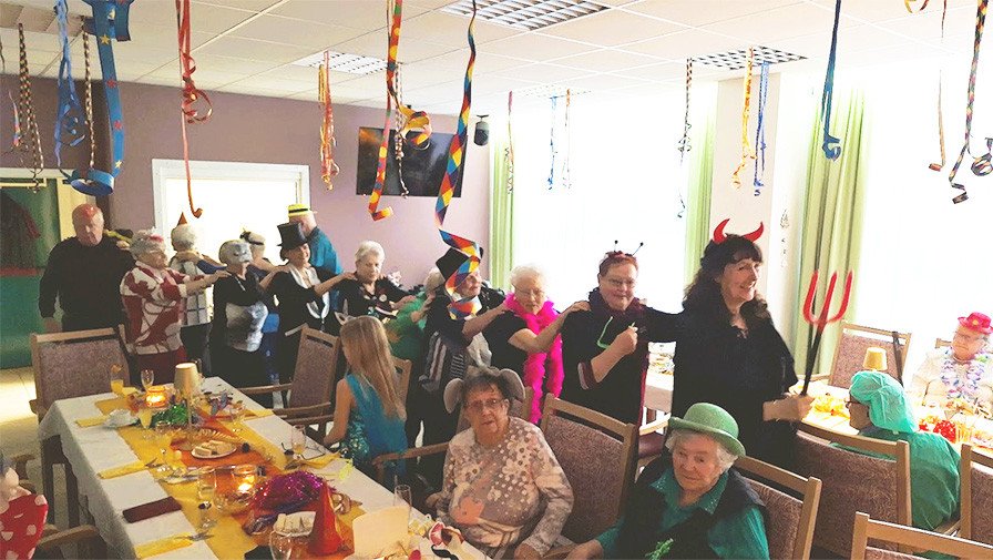 Das Team der ProCurand Seniorenresidenz Cottbus und die Bewohner*innen feiern Fasching mit bunten Kostümen und fröhlichem Tanz.