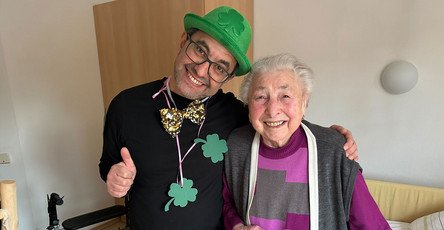 Neujahrsgruß im ProCurand Pflegestift Pfarrer Lukas in Cham: Bewohnerin mit Glücksboten Kleeblatt beim Rundgang durchs Haus.