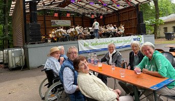 In der ProCurand Seniorenresidenz Am Görnsee genießen die Bewohner*innen bei einem kühlen Getränk die Klänge der Bravoer Brassband auf der Waldbühne Damsdorf.