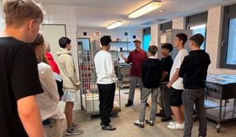 Ein Mitarbeiter der ProCurand Seniorenresidenz Bölschestraße gibt den Schüler*innen der Wilhelm-Bölsche-Oberschule spannende Einblicke in den Berufsalltag.