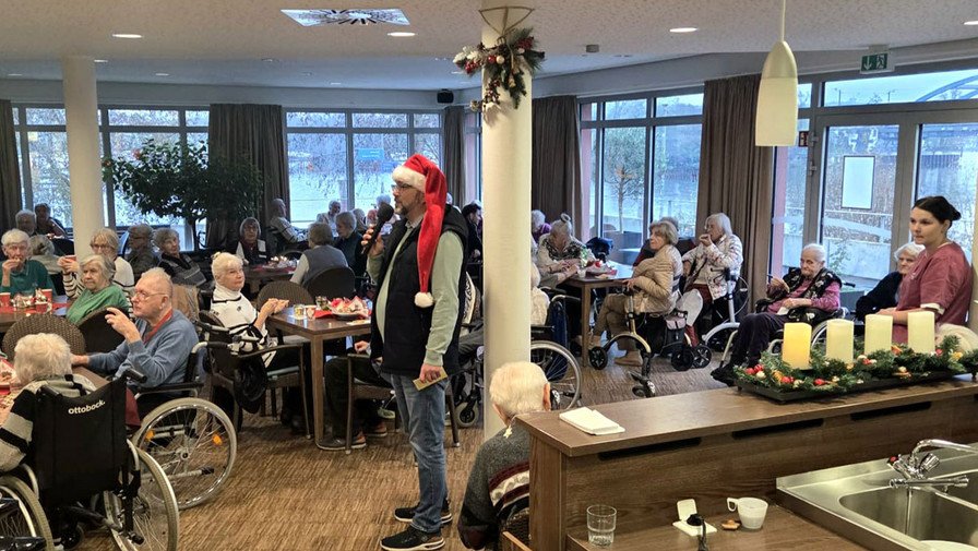 Bewohner*innen feiern den Weihnachtsmarkt im Café Havelterrasse der ProCurand Seniorenresidenz Havelpalais und genießen gemeinsam Speisen und Musik.
