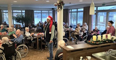 Bewohner*innen feiern den Weihnachtsmarkt im Café Havelterrasse der ProCurand Seniorenresidenz Havelpalais und genießen gemeinsam Speisen und Musik.