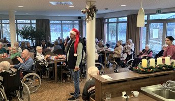 Bewohner*innen feiern den Weihnachtsmarkt im Café Havelterrasse der ProCurand Seniorenresidenz Havelpalais und genießen gemeinsam Speisen und Musik.