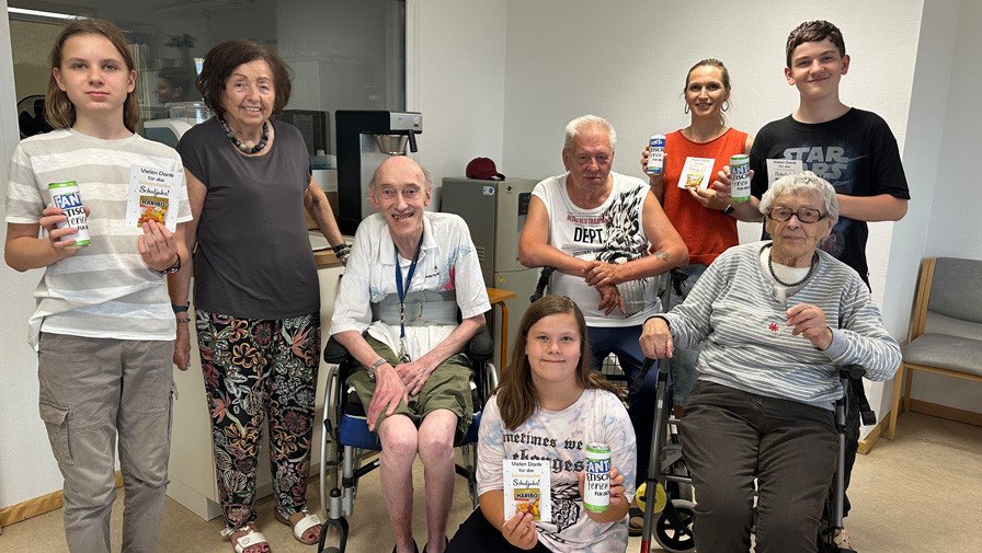 Senior*innen und Schüler*innen des Projekts „Jung trifft Alt“ im ProCurand Pflegestift Pfarrer Lukas stehen am letzten Schultag nebeneinander und zeigen stolz die kleinen Abschiedsgeschenke in die Kamera.