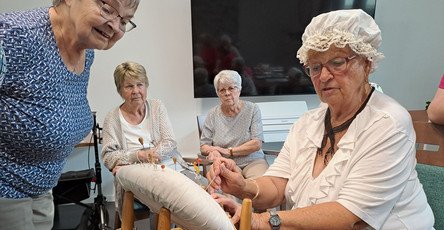 In der ProCurand Residenz Am Hallorenring zeigt Mieterin Monika Hennig konzentriert ihr Klöppel-Hobby, während die anderen Senior*innen gespannt zuschauen und jede Bewegung aufmerksam verfolgen. Die Begeisterung ist deutlich spürbar.
