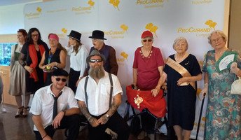 Bewohner*innen und Mitarbeitende der ProCurand Seniorenresidenz Am Straussee posieren kostümiert auf dem roten Teppich, die Stimmung ist ausgelassen und festlich.