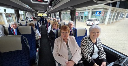 Im Bus sitzt die fröhliche Reisegruppe aus der ProCurand Residenz Am Hallorenring, die sich auf den gemeinsamen Ausflug nach Berlin freut.