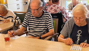 Bewohner*innen in der ProCurand Seniorenresidenz Bölschestraße beim Bingo spielen