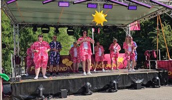 Das Team der ProCurand Seniorenresidenz Am Görnsee begeistert mit einem farbenfrohen Mallorca-Party-Tanzauftritt auf der Bühne.