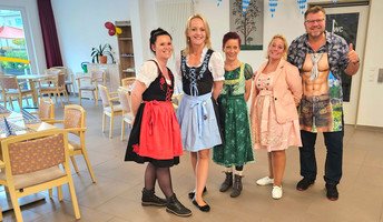 Mitarbeiter*innen der ProCurand Service-Wohnen Wriezener Straße in Strausberg feiern fröhlich unteranderem im Dirndl beim Oktoberfest.
