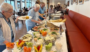 Am Buffet im Restaurant Vier Jahreszeiten der ProCurand Seniorenresidenz Bölschestraße genießen die Mieter*innen des Service-Wohnens die gemeinsame Grillrunde.
