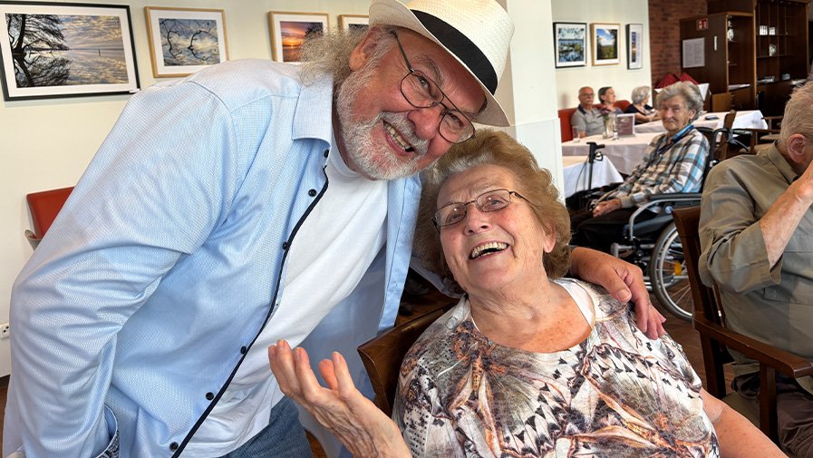 Entertainer Alf Weiss posiert gemeinsam mit einer Seniorin bei der Tanzveranstaltung in der ProCurand Seniorenresidenz Bölschestraße.
