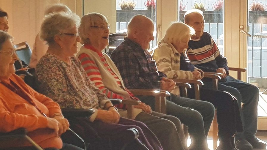 Bewohner*innen der ProCurand Seniorenresidenz Bölschestraße verfolgen die Lesung von Rosa und Jonathan Tennenbaum.