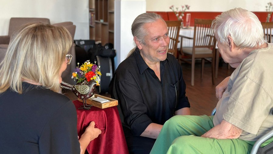 Nach dem Auftritt in der ProCurand Seniorenresidenz Bölschestraße im Gespräch: ein Mitglied des Duos Lovelysoul mit interessierten Seniorinnen.