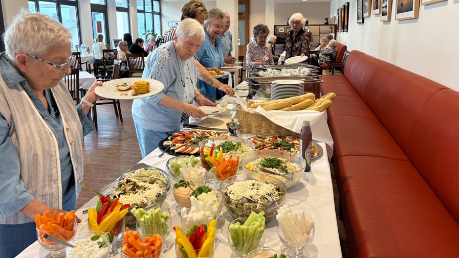 Am Buffet im Restaurant Vier Jahreszeiten der ProCurand Seniorenresidenz Bölschestraße genießen die Mieter*innen des Service-Wohnens die gemeinsame Grillrunde.