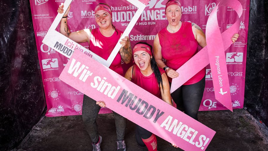 Stolze Muddy Angels – Vanessa, Denise und Isabelle zeigen ihre Startschilder und strahlen voller Vorfreude auf den Schlammlauf.