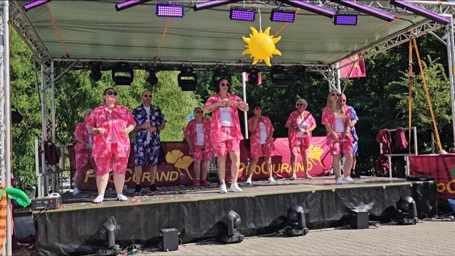 Das Team der ProCurand Seniorenresidenz Am Görnsee begeistert mit einem farbenfrohen Mallorca-Party-Tanzauftritt auf der Bühne.