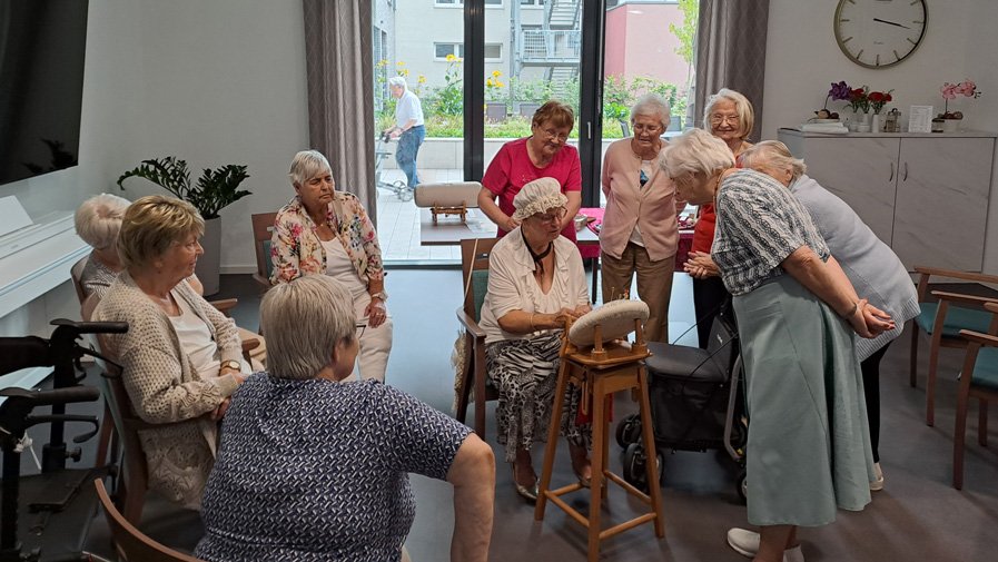 In der Residenz Am Hallorenring stehen die Senior*innen im Kreis um Monika Hennig, sichtlich beeindruckt von ihrer Technik und den feinen Details der Klöppelarbeiten. Lächeln und anerkennende Blicke zeigen die Faszination für das besondere Hobby.