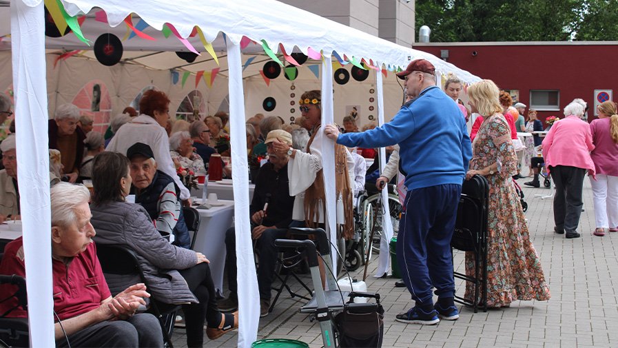 Fröhliche Stimmung beim Sommerfest in der ProCurand Seniorenresidenz Havelpalais: Bewohner*innen genießen Musik, Tanz und Erinnerungen an die 1950er Jahre.