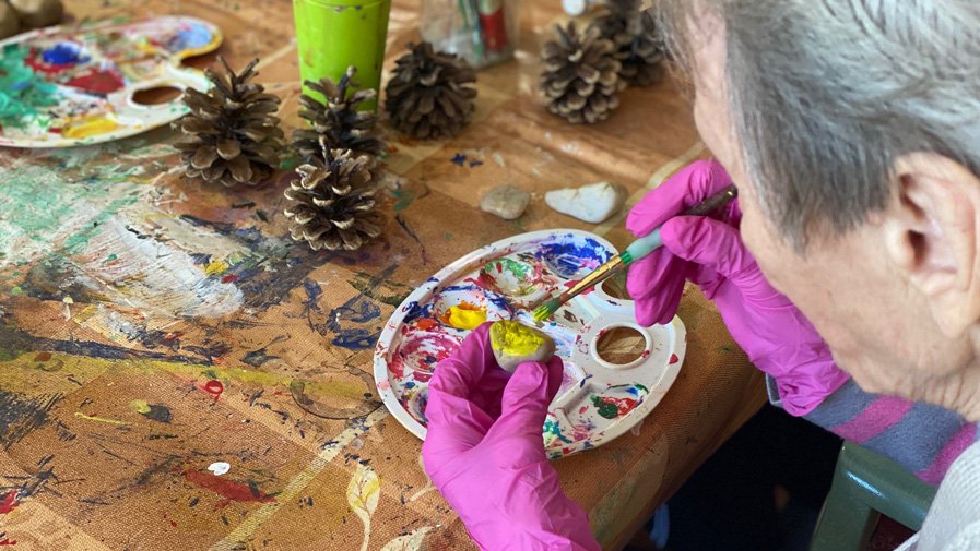 In der ProCurand Seniorenresidenz Senftenberg bemalten Bewohner*innen gemeinsam mit Alltagsbegleiterin Corina Gill liebevoll bunte Steine.