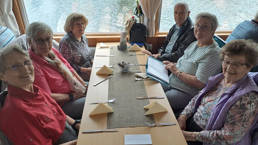 An Bord des Fahrgastschiffs genießen die Gäste der ProCurand Tagespflege Strausberg die gemütliche Runde am Tisch und freuen sich darauf, ihr Essen zu bestellen.