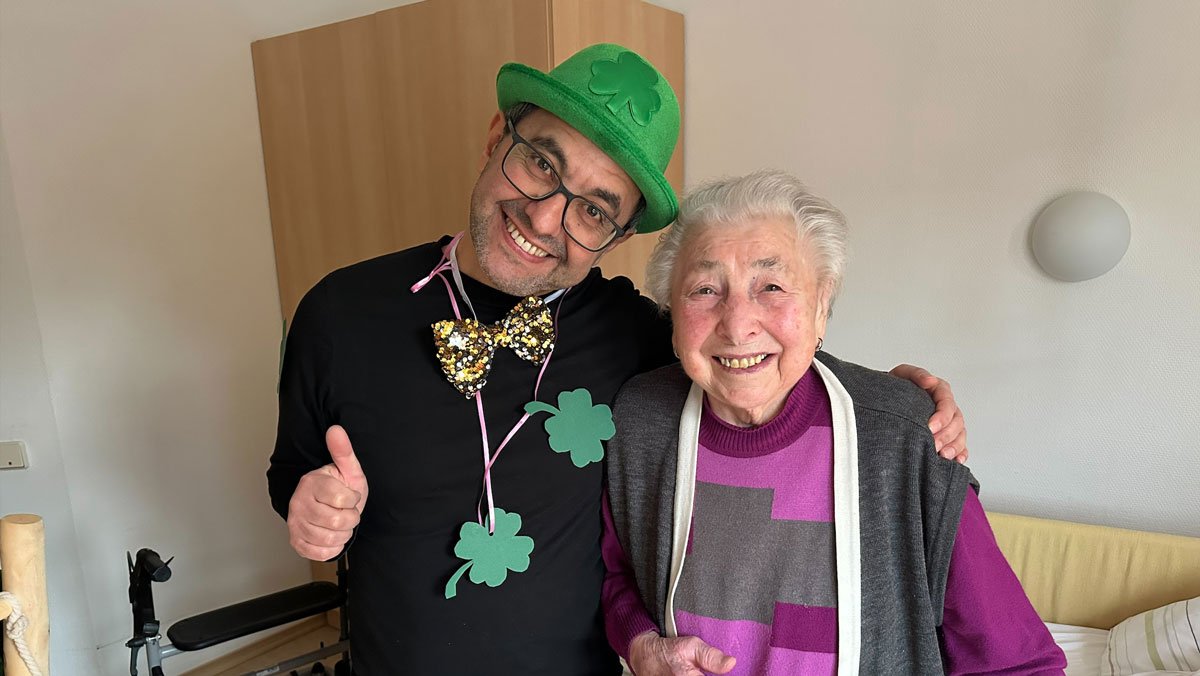 Neujahrsgruß im ProCurand Pflegestift Pfarrer Lukas in Cham: Bewohnerin mit Glücksboten Kleeblatt beim Rundgang durchs Haus.