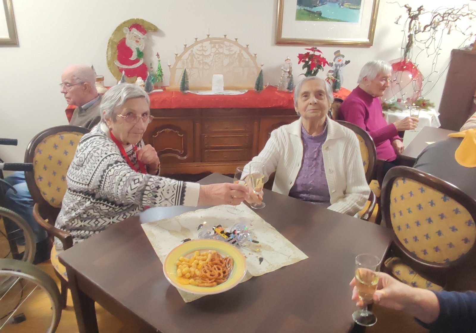 Bewohner*innen des ProCurand Seniorenzentrums Am Herzogschloss in Sulzbach-Rosenberg stoßen bei Sekt und kleinen Knabbereien gemeinsam auf das neue Jahr an.