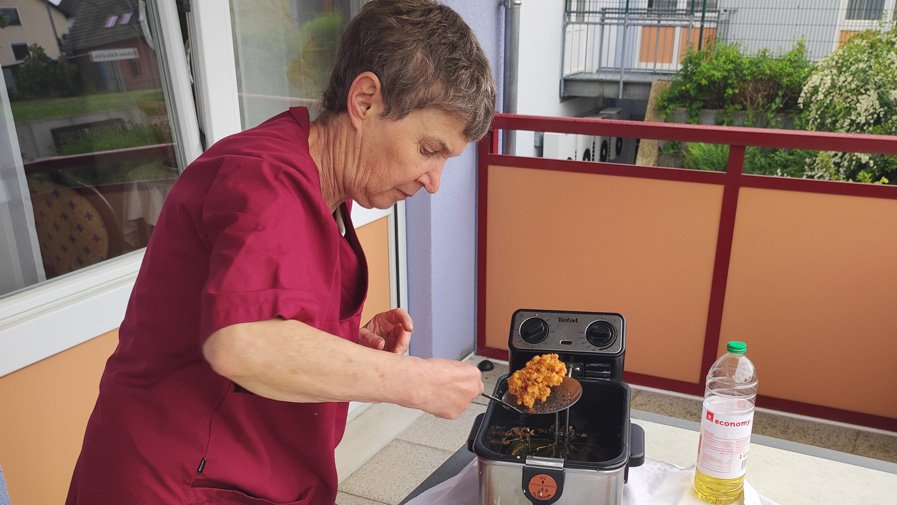Im ProCurand Seniorenzentrum Am Herzogschloss holt Betreuerin Anita Stubenvoll die frisch frittierten Holunderblütendolden aus der Fritteuse.